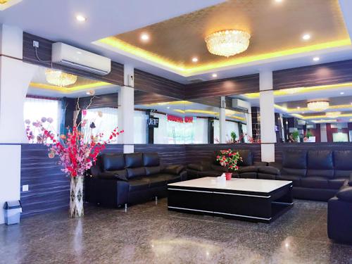 a waiting room with couches and a table and flowers at De Best Hotel in Nagoya