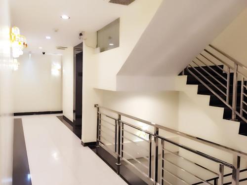 a staircase in a house with white walls and black railings at De Best Hotel in Nagoya