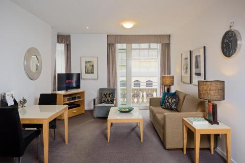 a living room with a couch and a table at Treasury on Collins Melbourne in Melbourne
