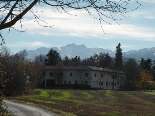 a house on a road with mountains in the background at Tetto Nuovo B&B in Cuneo