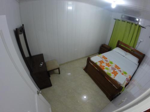 a small bedroom with a bed and a green curtain at Zippy´s Sea View Apartments in San Andrés