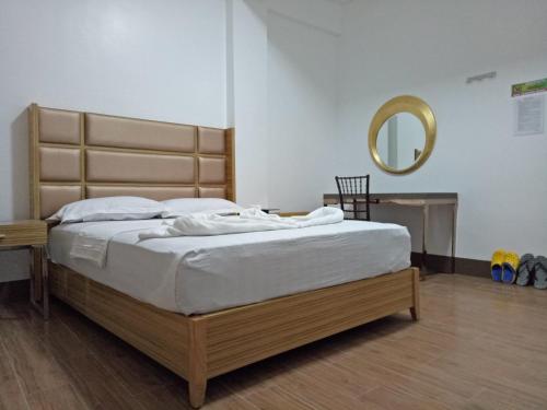 a bedroom with a large bed with a mirror at Meaco Hotel - Anilao in Mabini