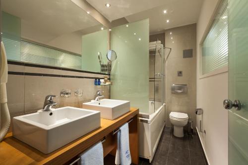 a bathroom with a white sink and a toilet at Tropical Hotel in Athens