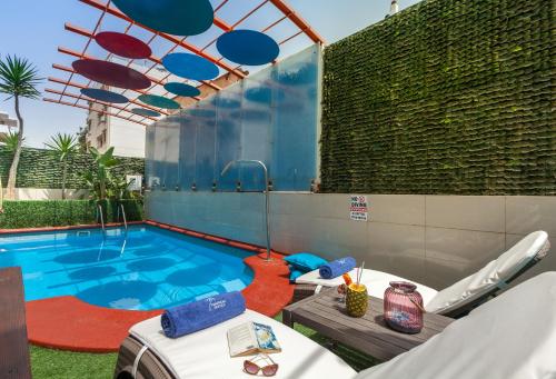 ein Pool mit einem Tisch und Stühlen daneben in der Unterkunft Tropical Hotel in Athen