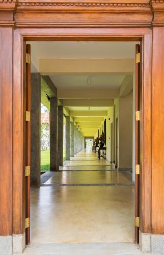 an internal hallway of a building with an open door at Taru Villas The Long House - Bentota in Bentota