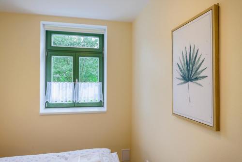 a bedroom with a window and a picture of a pineapple at Slovanský penzion in Mikulčice