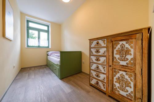 a bedroom with a bed and a dresser and a window at Slovanský penzion in Mikulčice