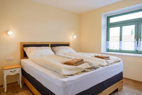 a bedroom with a bed with white sheets and a window at Slovanský penzion in Mikulčice