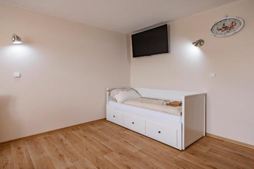 a room with a bed with a tv on the wall at Slovanský penzion in Mikulčice
