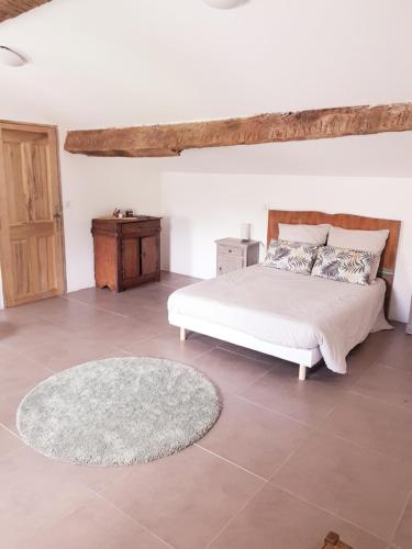 a bedroom with a white bed and a rug at Chambres entre Ventoux et luberon in Sault-de-Vaucluse