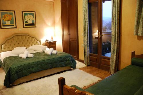 a bedroom with a bed with a green bedspread at Villa Virginia Hotel in Voútiron