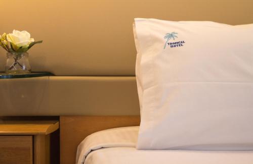 a bed with a pillow with a palm tree on it at Tropical Hotel in Athens