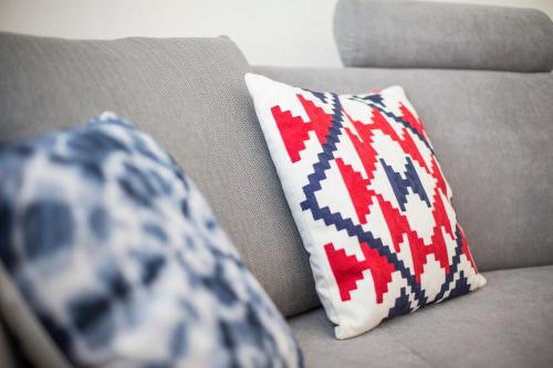 a couch with two pillows sitting on it with at Apartamenty4you - Apartamenty Atlantic in Sopot