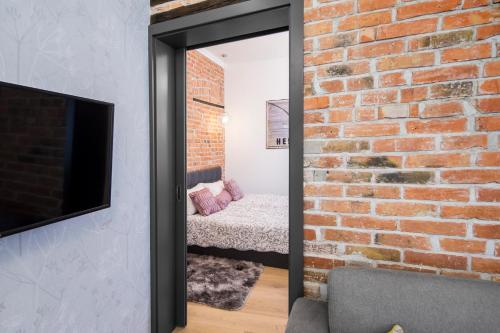 a mirror in a room next to a brick wall at Apartamenty4you - Apartamenty Atlantic in Sopot