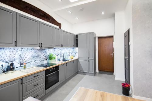 a kitchen with gray cabinets and blue and white tiles at Apartamenty4you - Apartamenty Atlantic in Sopot