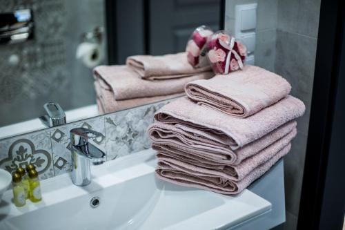 a pile of towels sitting on top of a bathroom sink at Apartamenty4you - Apartamenty Atlantic in Sopot