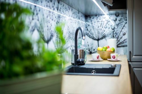 a kitchen counter with a sink and a bowl of fruit at Apartamenty4you - Apartamenty Atlantic in Sopot