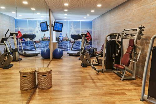 a gym with several treadmills and cardio machines at Steigenberger Inselhotel in Konstanz