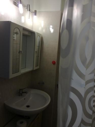 a bathroom with a sink and a shower curtain at Casa Solemare in Torre Lapillo