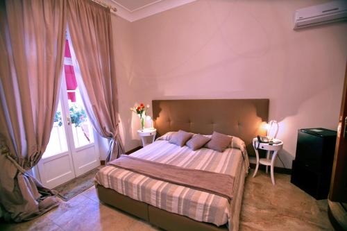 a bedroom with a bed with two tables and a window at B&B Milu' in Crotone