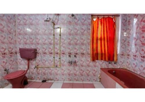 W łazience znajduje się czerwona wanna, toaleta i umywalka. w obiekcie Hotel parikalp New w mieście Pachmarhi