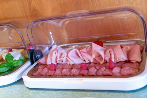 a plastic container filled with meat and a strawberry on top at Gästehaus Nora in Stein bei Loipersdof