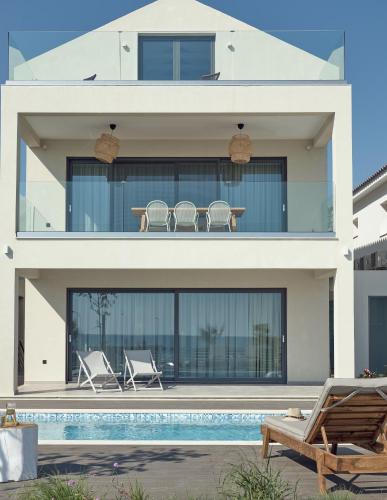 a house with a swimming pool in front of it at Maritimus Excelsior in Alykes