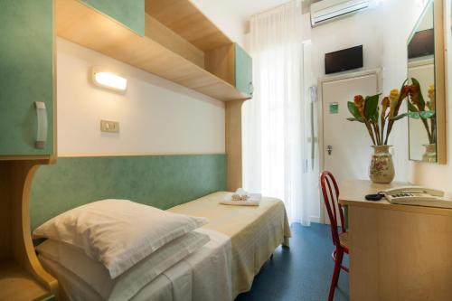 een slaapkamer met een bed, een bureau en een tafel bij Hotel Erika in Rimini