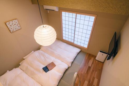 a small bedroom with a bed and a window at Miro Sanjo Saiin Tei in Kyoto