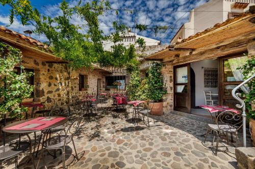 a patio with a bunch of tables and chairs at Albergo Diffuso Mannois in Orosei