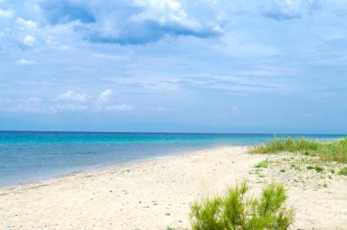 a sandy beach with the ocean in the background at Thea Suites in Nea Kalikratia