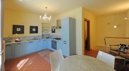 een keuken met blauwe kasten en een tafel met stoelen bij Villa Seriola in Limone sul Garda
