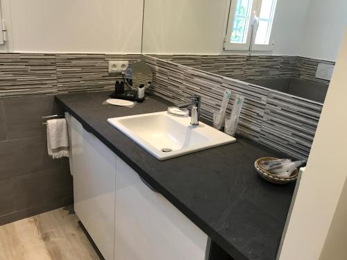 a bathroom with a sink and a black counter top at Windward in Saint-Tropez