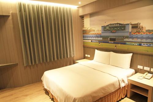 a hotel room with a bed and a baseball game on the wall at La Hotel-Baseball Theme Hall in Kaohsiung