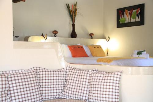 a bedroom with a bed with orange and white pillows at Tantebane Game Ranch in Tantebane