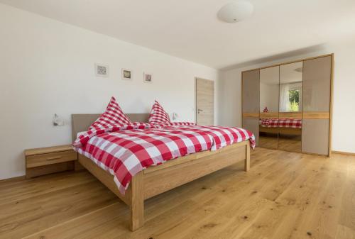 um quarto com uma cama com duas almofadas vermelhas e brancas em Ferienwohnung Baßler em Kappelrodeck