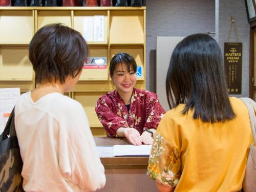 three children standing around a counter with a woman at Arima Onsen Motoyu Ryuusenkaku in Kobe