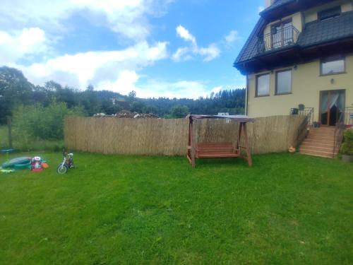 a yard with a house and a fence at Willa Pawlikowskich in Poronin