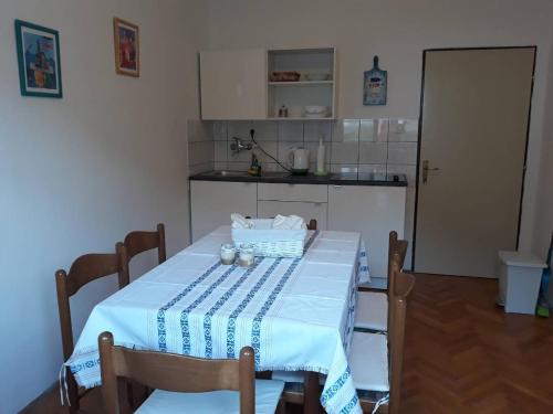 a kitchen with a table with a blue and white table cloth at Apartments Pag Holiday in Pag