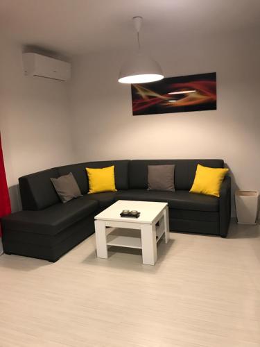 a living room with a black couch and a white coffee table at Apartament Kilfowa 15/8 in Mechelinki
