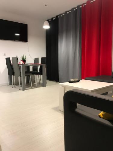メヘリンキにあるApartament Kilfowa 15/8の赤いカーテン、テーブルと椅子が備わる客室です。
