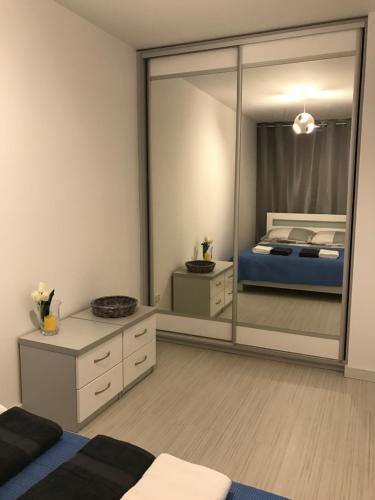 een slaapkamer met een grote spiegel en een bed bij Apartament Kilfowa 15/8 in Mechelinki