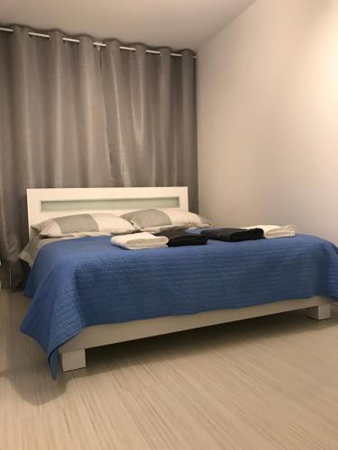 a bedroom with a large bed with a blue blanket at Apartament Kilfowa 15/8 in Mechelinki