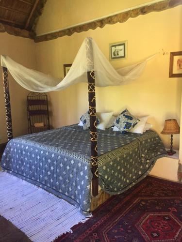 a bedroom with a bed with a canopy at Nyore Hillside Retreat in Mbarara