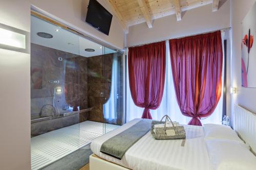 a bedroom with a bed and a tub with red curtains at Tenuta Valdorso in Montechiaro D'acqui