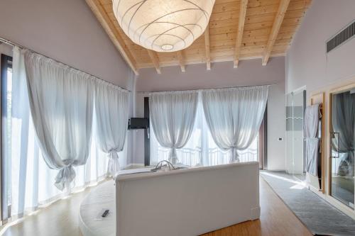 a large white room with windows and a large white couch at Tenuta Valdorso in Montechiaro D'acqui