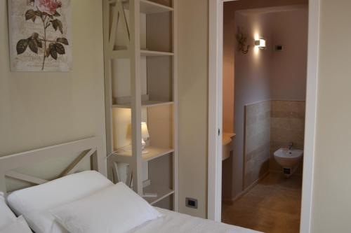 a bedroom with a bed and a bathroom with a sink at Hotel Danila in Portoferraio