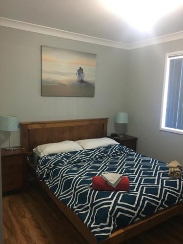 a bedroom with a bed and a painting on the wall at Green Meadow in Nowra