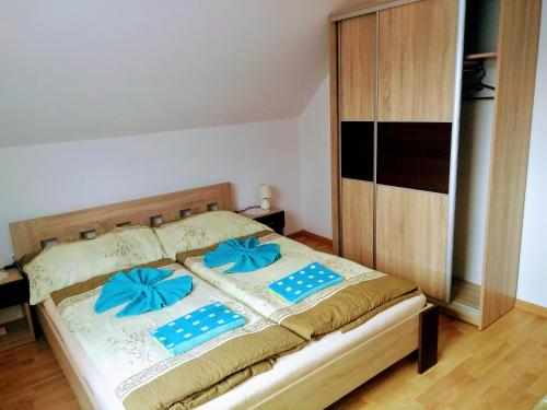 a bedroom with a bed with blue bows on it at Apartmán 80 in Oravský Podzámok