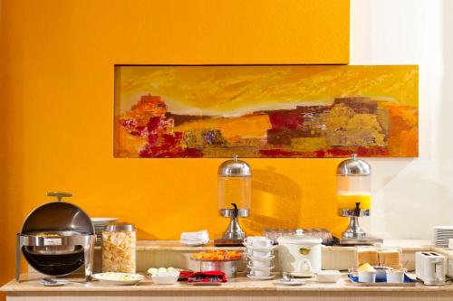 a counter with some food on a yellow wall at Zuri Express Hotel Pekanbaru in Pekanbaru